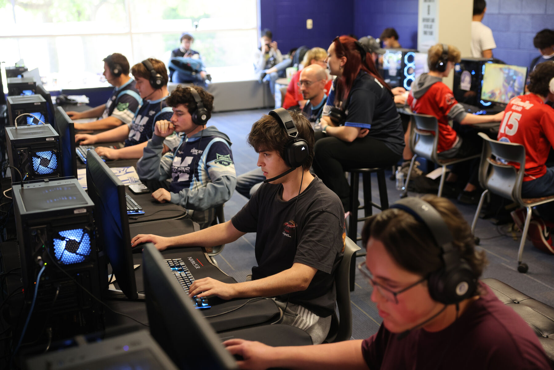 Players in team jerseys competing at a PIEA LAN event